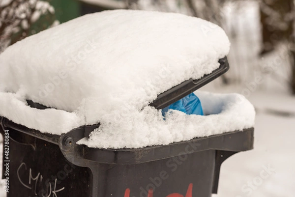 Fototapeta Winter garbage bin covered by snow. Environmental object.