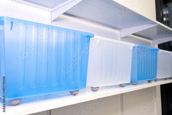 Fototapeta Organization of the space at home, storage of things, a lot of plastic boxes, new container boxes for convenient storage of things.