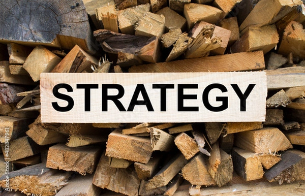 Fototapeta Wall firewood. Background of dry chopped firewood logs in a pile and plate with text Strategy