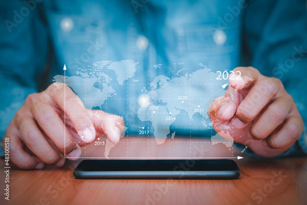 Fototapeta Businessman uses a smartphone to business analysing with financial graph data. Business finance background. business finance technology, business finance technology and investment concept