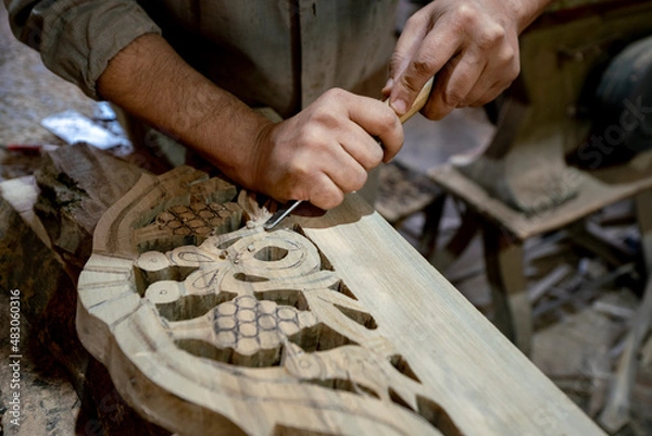 Fototapeta Carve wood Close-up. Hands of craftsmen carve with a hollow in hand on carpentry workbench