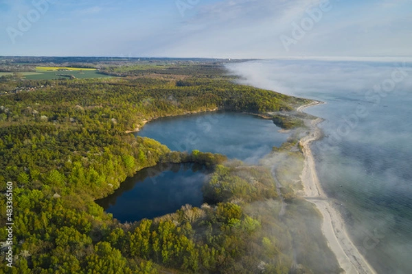 Fototapeta fog over the ocean hitting the shore in denmark