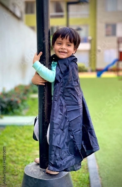 Fototapeta Niño feliz en el poste del parque