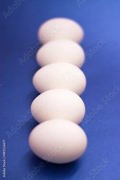 Fototapeta Five white raw eggs lie on the table. Vertical photo, large eggs. Preparing for Easter. Easter Ingredients