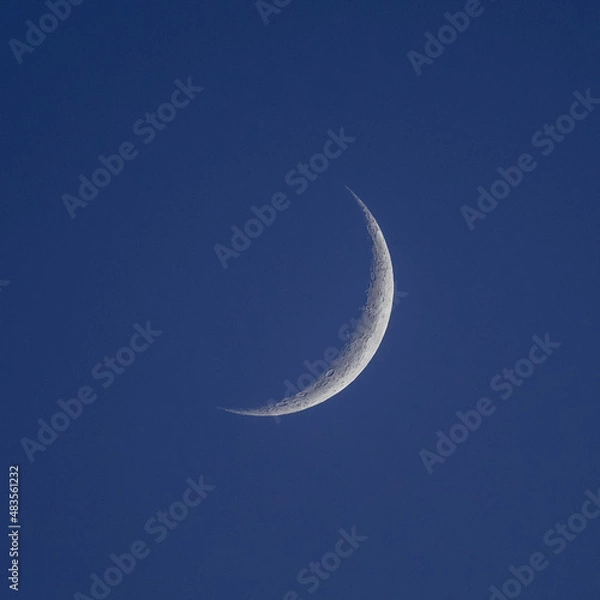 Obraz A waning crescent moon in a dark sky
