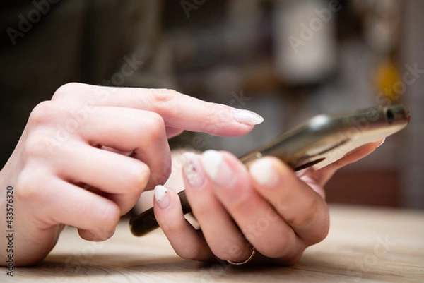 Obraz スマートフォンを操作する女性の手