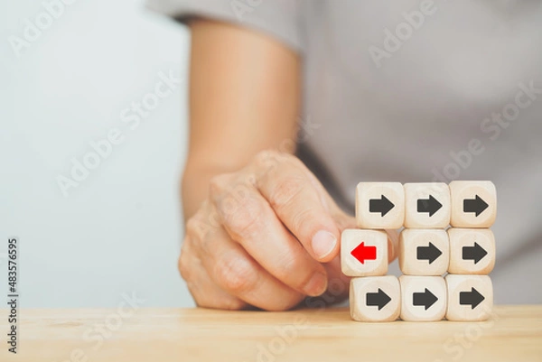 Fototapeta senior's hand choose red arrow, difference direction from others, for innovation, creative idea, leadership, outstanding performance concept