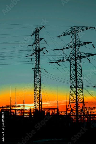 Fototapeta Power poles against the setting sun