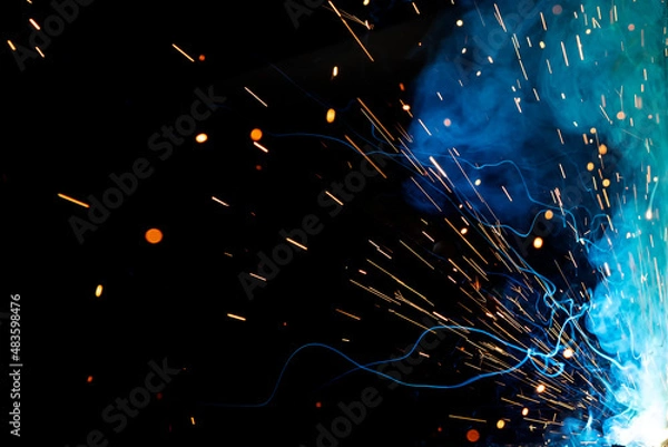 Fototapeta Close up view and background of the gas metal arc welding (GMAW) process with sparks, light, bokeh effect and smoke.