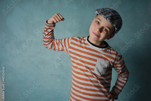 Obraz portret młodego chłopaka na tle niebieskiego muru 