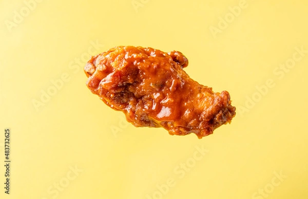 Obraz A piece of fried buffalo chicken wing on a bright background.