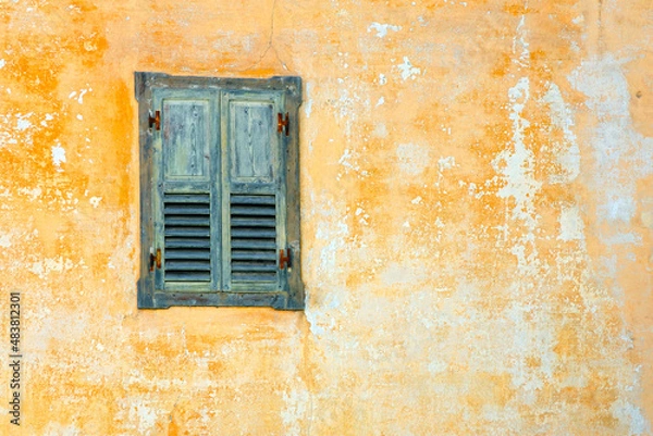 Fototapeta Retro style yellow window with shattered glass on dirty damaged white walls. Detail of window in abandoned rural house
