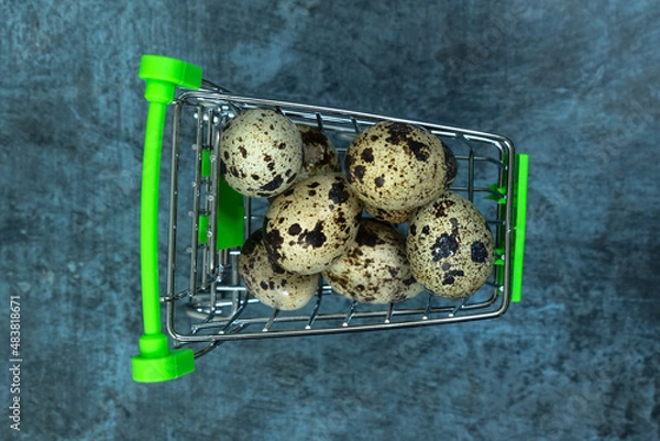 Obraz Easter background. Quail eggs in a cart on a dark background.