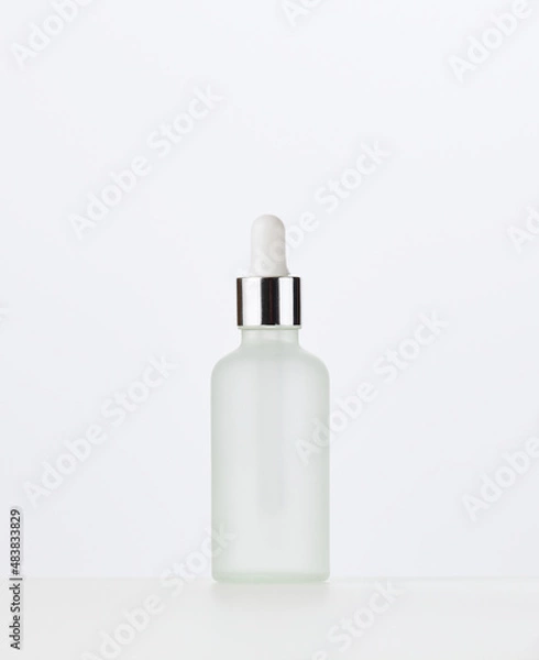 Obraz white glass bottle with a pipette on a white background. Template for cosmetic liquid products