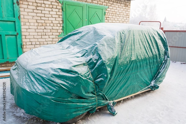 Fototapeta Car covered in winter. Sheltered car in winter. Tent for the car.