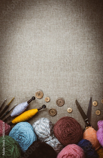 Fototapeta Panoramic view of composition with knitting accessories: balls of wool yarn, set of knitting needles, hooks, and other knit tools on wooden background. Long banner, top view, copy space, flat lay.