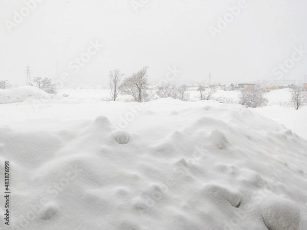 Fototapeta Viewing a snowfield from behind a lump of fallen snow (Kutchan, Hokkaido, Japan)