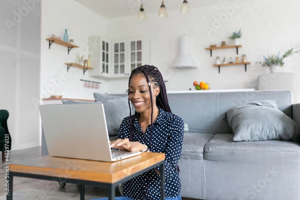 Fototapeta Beautiful young black woman has a zoom call remote work or study online in from laptop classes