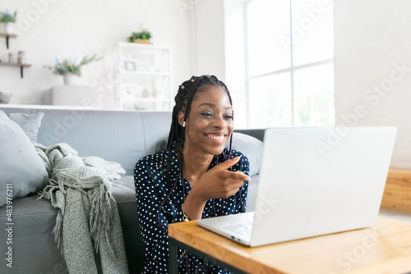Fototapeta Beautiful young black woman has a zoom call remote work or study online in from laptop classes