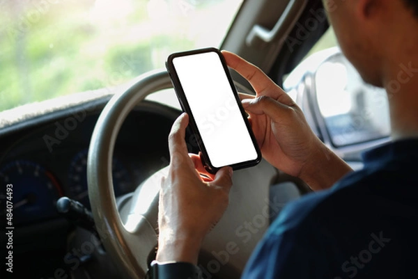 Fototapeta Close up view businessman sitting in car and using smart phone. Blank screen for your advertising text.