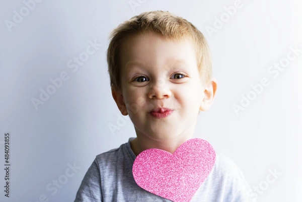 Fototapeta little emotional, smiling child with a pink heart