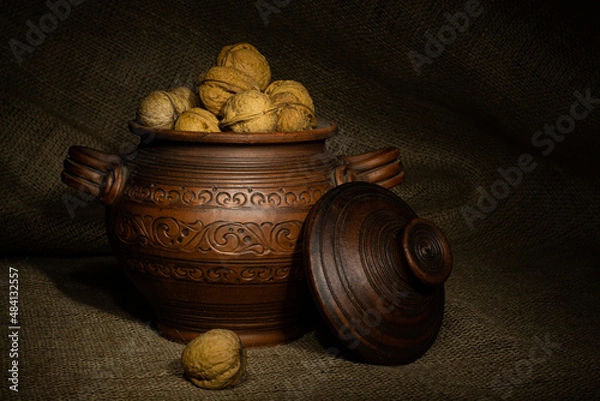 Obraz Clay pot with walnuts