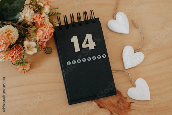 Fototapeta Wooden calendar on February 14 with roses and heart.