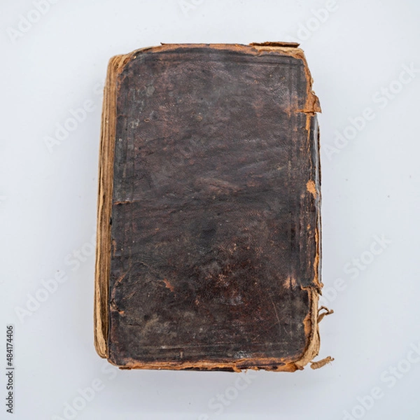 Fototapeta An Old Leather Covered Book Sits Flat. The worn edges lighten the color of the leather.