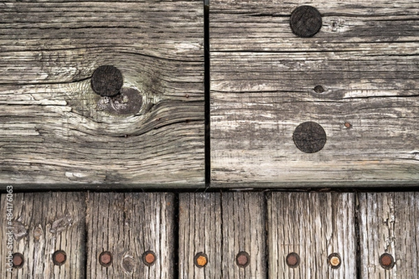 Fototapeta Wood Planks From A Boardwalk Connecting Together. Two large planks meet at the top of the image, with five smaller planks abutting the larger two planks.