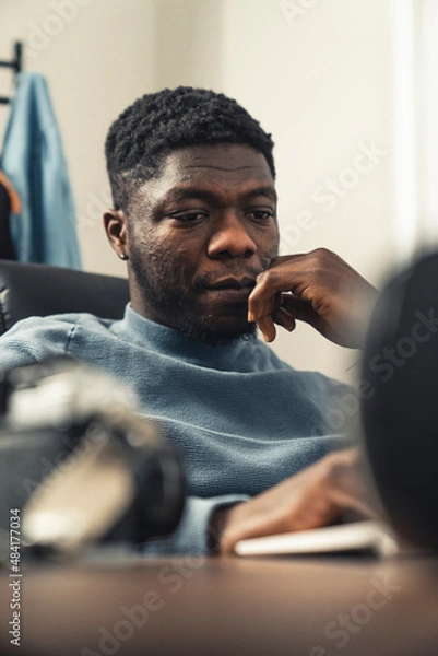 Obraz Focused thinking black man working on laptop computer - portrait shot. High quality photo
