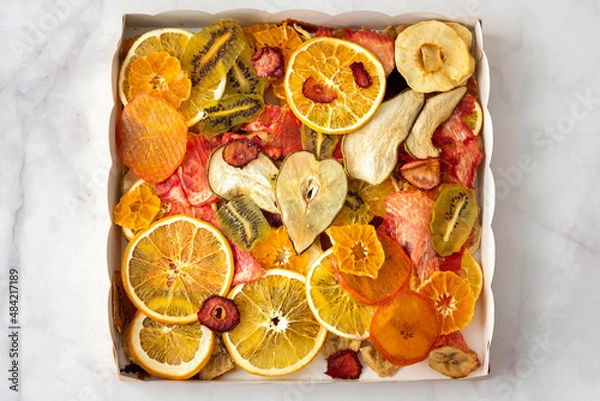 Fototapeta various multi-colored dry fruits in a kraft box, top view