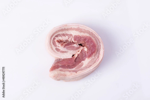 Fototapeta Close up freshness cutting slide pork belly raw or streaky pork on white background. .A meat boneless cut of fatty meat from the belly of a pig. This dish is considered a delicacy in many countries.