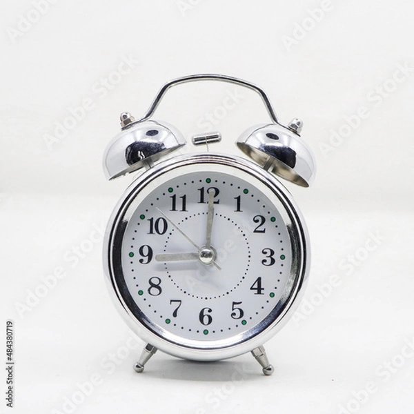 Fototapeta a vintage classic ringing alarm clock with a silver body and white analog dial isolated in a white background