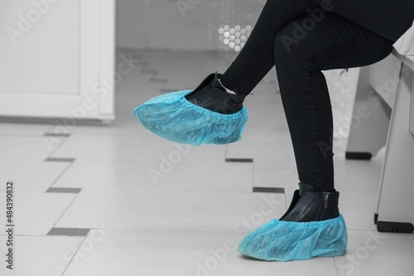 Fototapeta Abstract image with feet in boot covers in a hospital.