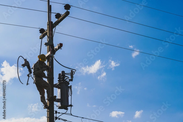Fototapeta The silhouette of power lineman replacing a transformer and hotline clamp, bail  clamp. Using clamp stick grip all type, wearing personal protective equipmen,