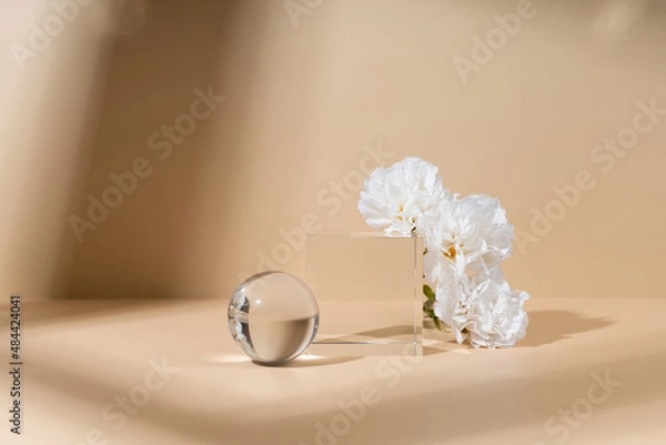 Fototapeta Skincare and cosmetic product showcase stand photography for online marketing include crystal ball and crystal cube stand on beige background with white flower