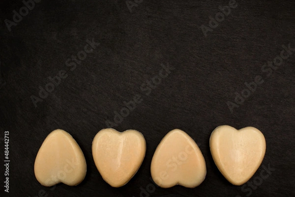 Obraz Four heart-shaped soaps on black background. Love valentine concept. Flat lay
