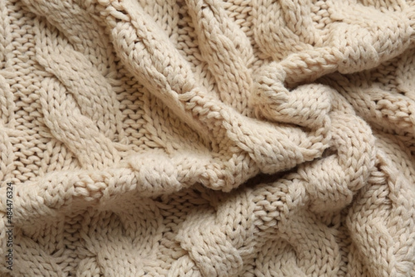 Fototapeta Beige knitted fabric with beautiful pattern as background, top view