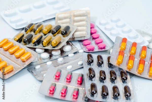 Fototapeta Tablets and medical capsules in a blister pack isolated on white background