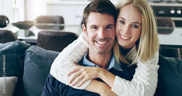 Obraz Were young and in love. Cropped portrait of an affectionate young couple sitting on their sofa at home.