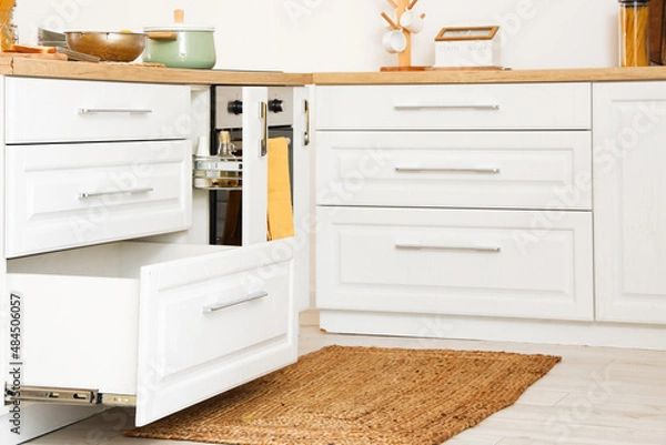 Fototapeta Opened drawers in light kitchen interior