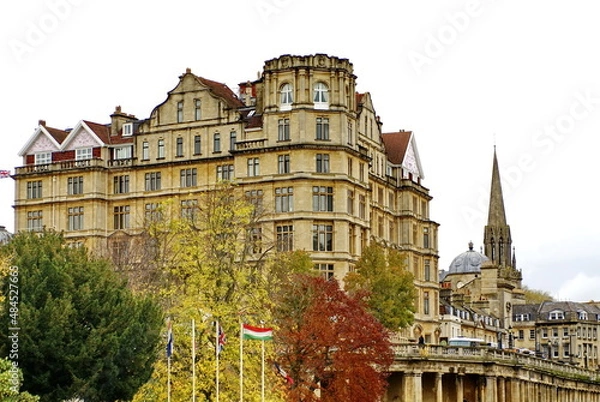 Fototapeta Georgian architecture on the bank of the River Avon in Bath, England, surrounded by autumn foliage