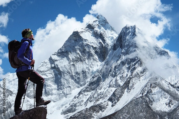 Fototapeta Climber reaches the summit of mountain peak enjoying the view of Ama Dablam on the way to Everest Base Camp. Sagarmatha national park, Khumbu valley, Nepal
 Success, freedom and happiness