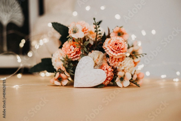 Fototapeta wooden table with a bouquet of flowers and a white heart
