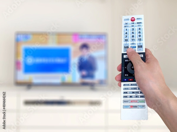 Fototapeta 薄型テレビの前でリモコンをかざす手