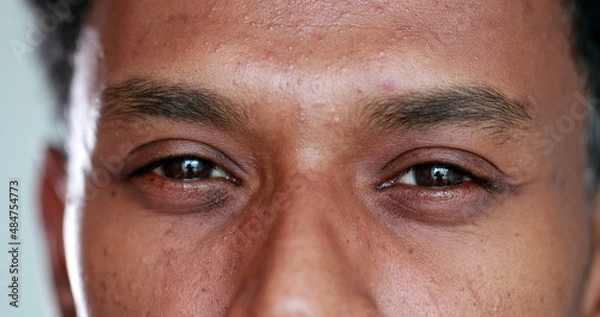 Fototapeta Close-up face african descent closing and opening eyes, smiling reaction