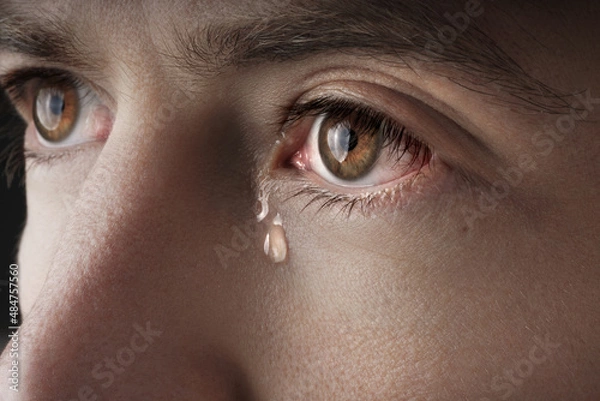 Fototapeta Closeup of young crying man eyes with a tears