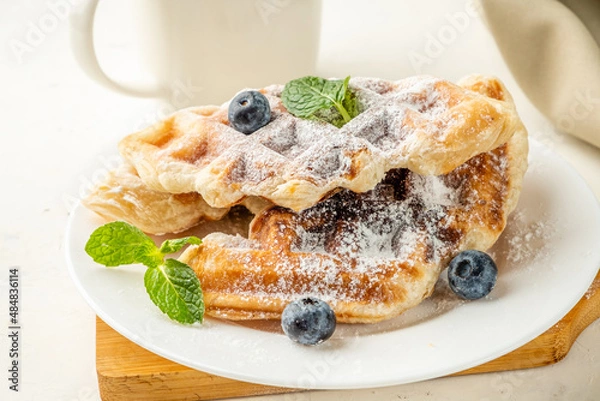 Obraz Fresh croffles on a light background. Mix of waffles and croissant.