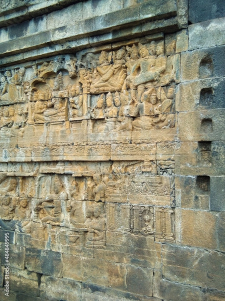 Fototapeta Ancient carved wall at Borobudur Temple. Borobudur Temple is an ancient Buddhist temple which is located in Magelang, Central Java, Indonesia.