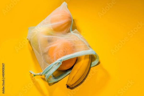 Obraz  Fruits in a disposable bag on a yellow background. High quality photo